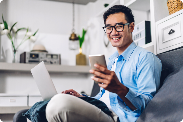 young-smiling-asian-man-relaxing-using-laptop-computer-working-video-conference-meeting-home-young-creative-man-looking-screen-typing-message-with-smartph