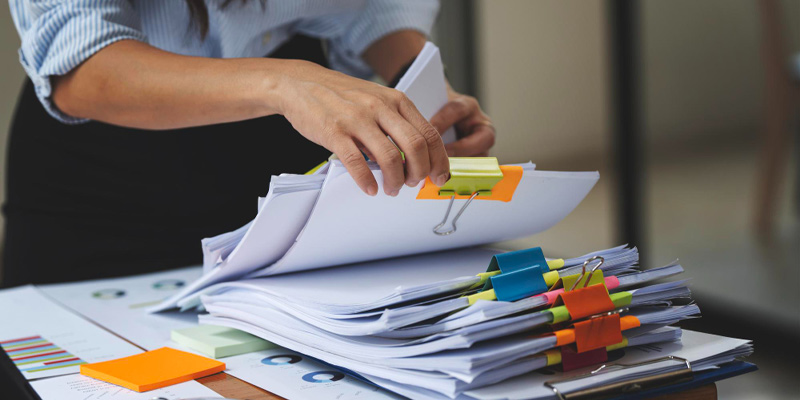 Lawyer reviewing a client file retention schedule on a digital document management dashboard in a bright modern law office.